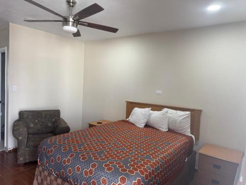 a bedroom with a bed and a ceiling fan at Townhouse Inn and Suites in Brawley