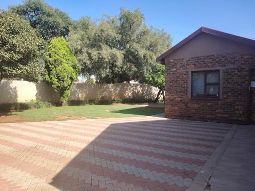 a brick building with a window and a brick driveway at Zea 85 BnB in Vereeniging