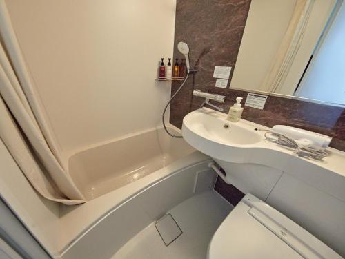 a bathroom with a toilet and a sink and a tub at Dorsett by Agora Osaka Sakai in Sakai