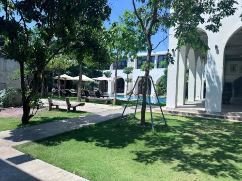 a park with a swing set in the grass at STONE AGE Boutique in Kampot