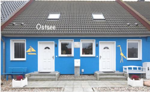 a blue building with white doors and a black roof at Ferienhaus Ostsee in Pruchten