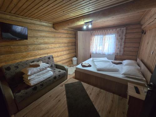 een kleine slaapkamer met een bed en een bank bij Poiana Bucovineana in Poiana Negrii