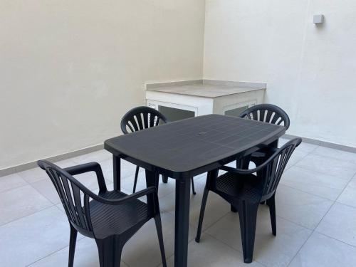 a black table and chairs in a room at Swieqi Malaika New Apt 2 with COURTYARD in Is-Swieqi