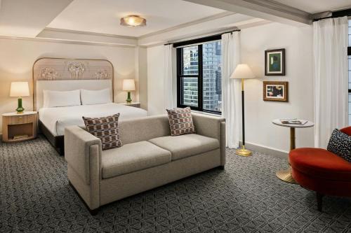 a hotel room with a bed and a couch at The Talbott, Autograph Collection in Chicago