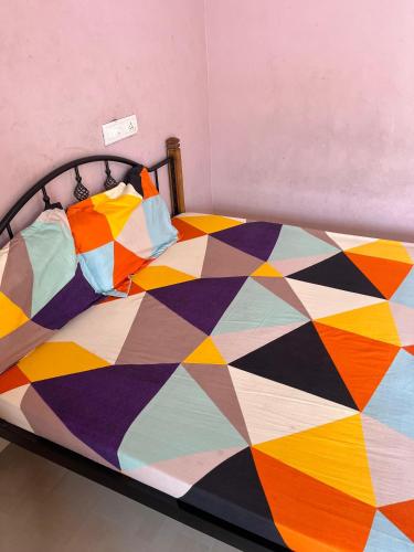 a bed with a colorful quilt on it at KRN Residency in Nagari