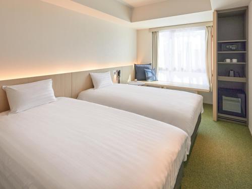 Postel nebo postele na pokoji v ubytování Dorsett by Agora Osaka Sakai