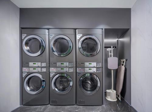 four washers and dryers are lined up in a room at CityNote Hotel -Guangzhou Beijing Road Pedestrian Street Yuexiu Park Branch in Guangzhou