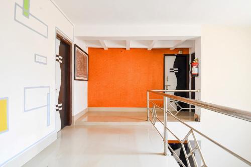 a hallway with an orange wall and a staircase at Super Hotel O Swaranpuri Near KIIT Square in Bhubaneshwar