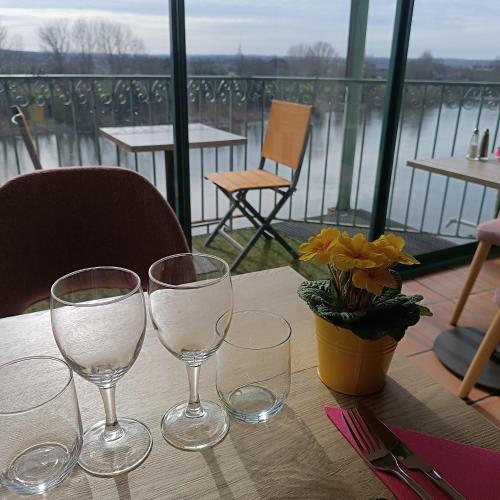 Una mesa con cuatro copas de vino encima. en CÔTE GARONNE le BALCON DES DAMES -hôtel et restaurant- Tonneins Fauillet Marmande - vue panoramique bord de Garonne chambres climatisées, en Tonneins