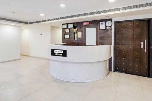 a lobby with a reception counter and two doors at Palette Country Club Surat in Surat