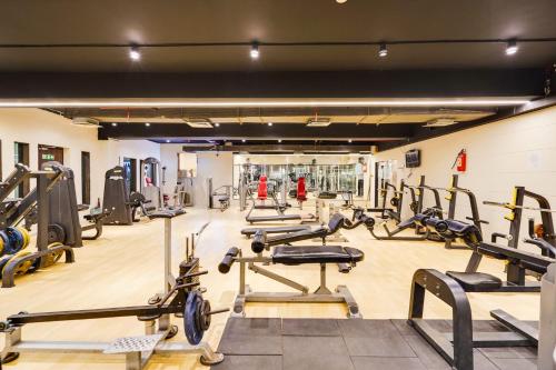 a gym with a lot of treadmills and machines at Palette Country Club Surat in Surat
