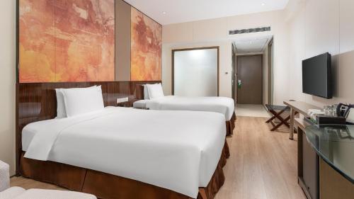 a hotel room with two beds and a television at Holiday Inn Nanjing Aqua City by IHG in Nanjing