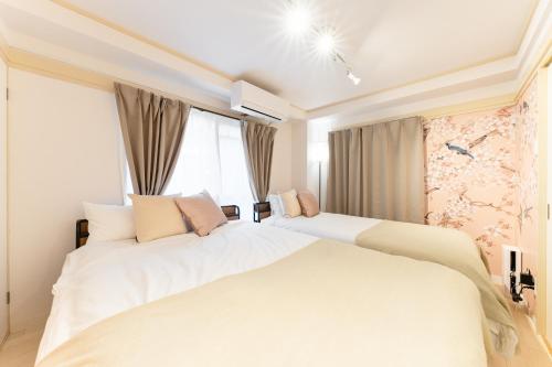 a bedroom with two white beds and a window at Japanese Art Room, 2Bed Room, 4Bed, Near Metro&JR station in Tokyo
