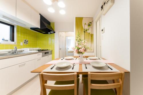 a kitchen with a wooden table with chairs and yellow tiles at Japanese Art Room, 2Bed Room, 4Bed, Near Metro&JR station in Tokyo