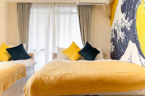 a bedroom with two beds with yellow and blue pillows at Japanese Art Room, 2Bed Room, 4Bed, Near Metro&JR station in Tokyo
