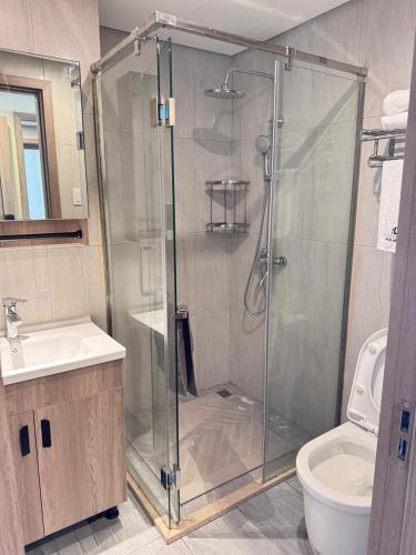a bathroom with a shower with a sink and a toilet at LCONDOTEL Hotel Studio with Balcony at Imperial Plaza near MOA NAIA PITX in Manila
