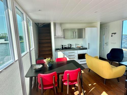 a kitchen and dining room with a table and chairs at Houseboat Robbedoes in Offingawier