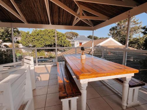 un tavolo in legno posto sopra un patio di Wildecrest & Ripplemead, Amblewood Guesthouse a Kenton-on-Sea