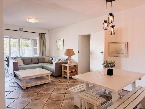 a living room with a table and a couch at Wildecrest & Ripplemead, Amblewood Guesthouse in Kenton on Sea