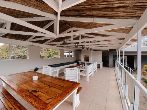 una sala da pranzo con tavoli in legno e sedie bianche di Sea La Vie, Amblewood Guesthouse a Kenton-on-Sea