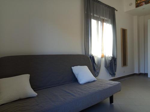 a couch with a pillow on it in a room at La Primula Roma, a 15 minuti da San Pietro in Rome