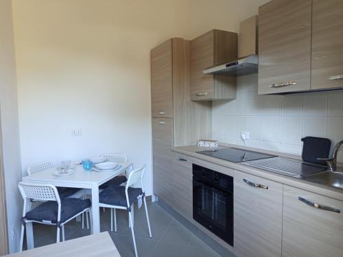 a kitchen with a table and a white table and chairs at La Primula Roma, a 15 minuti da San Pietro in Rome