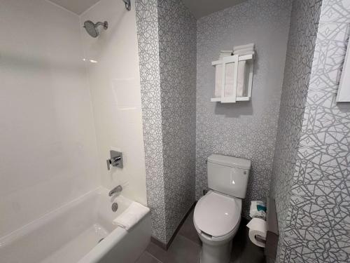 a bathroom with a toilet and a tub and a sink at Hampton Inn Milpitas in Milpitas