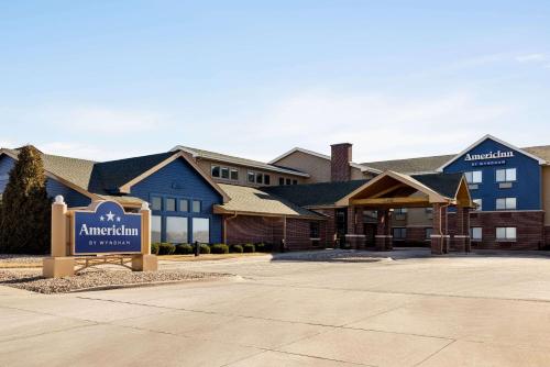 a hotel with a sign in front of a building at AmericInn by Wyndham Lincoln South in Lincoln