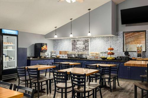a restaurant with tables and chairs and a kitchen at AmericInn by Wyndham Lincoln South in Lincoln