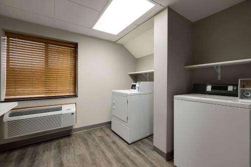 a kitchen with a washer and dryer and a window at AmericInn by Wyndham Lincoln South in Lincoln