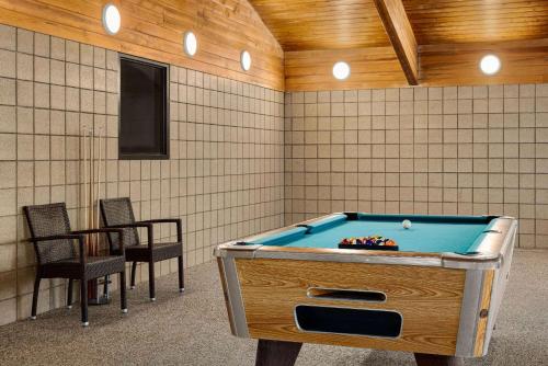 a room with a pool table and two chairs at AmericInn by Wyndham Lincoln South in Lincoln