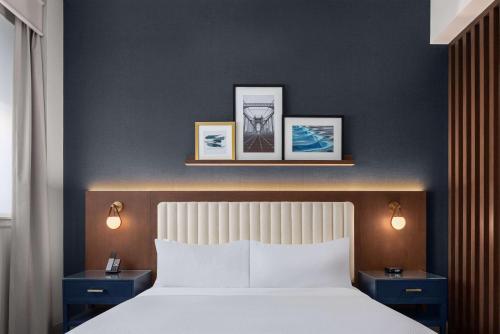 a bedroom with a white bed with two night stands at The Well House Hamilton, Tapestry Collection By Hilton in Hamilton