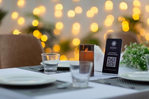 a table with plates and glasses and a menu on it at Hotel Park Royal in Dwarka