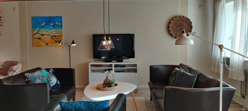 Øster HurupにあるHavhuset I Øster Hurup - i byen, ved strandenのリビングルーム(椅子、テーブル、テレビ付)