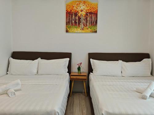 two beds sitting next to each other in a room at Sutera Avenue Rooftop Infinity Swimming Pool in Kota Kinabalu