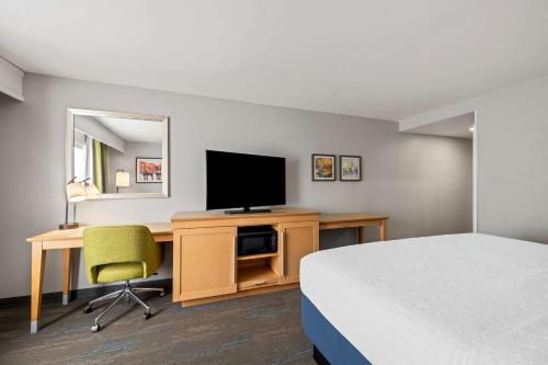 a hotel room with a bed and a desk with a television at Hampton Inn & Suites Wilson I-95 in Wilson
