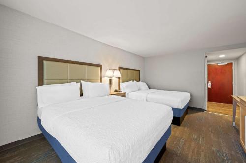 a hotel room with two beds and a hallway at Hampton Inn & Suites Wilson I-95 in Wilson