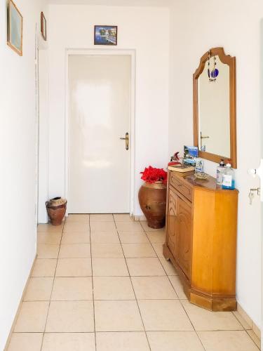 a bathroom with a mirror and a dresser and a door at Dina's Flowers - Alonnisos Summer Havens in Patitiri