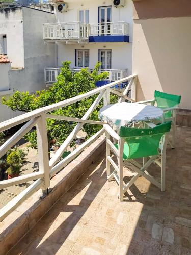 a table and chairs on the balcony of a building at Dina's Flowers - Alonnisos Summer Havens in Patitiri