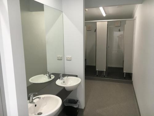 ein Badezimmer mit 2 Waschbecken und einem Spiegel in der Unterkunft Alpine Sports Lodge in Bright