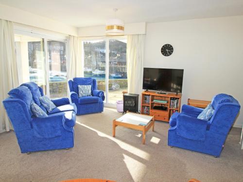 a living room with blue chairs and a tv at Glaslyn Harbour Views in Porthmadog