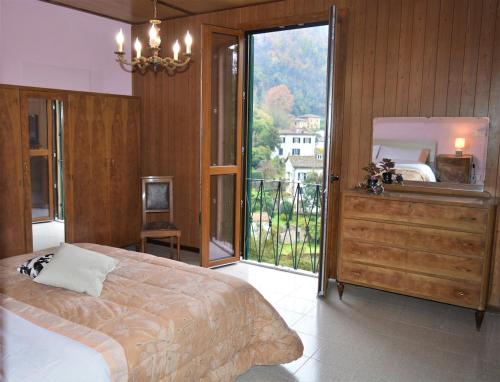 a bedroom with a large bed and a large window at Bellavista apartment in Bagni di Lucca