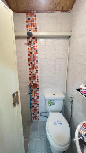 a bathroom with a toilet and a shower at Bnเกาะลิบงโฮมสเตย์ in Ko Muk