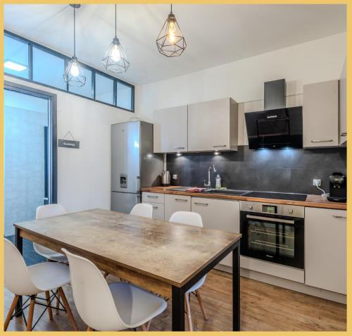 une cuisine avec une table en bois et des armoires blanches dans l'établissement Appartement T3 I Élégant I Annemasse, à Annemasse