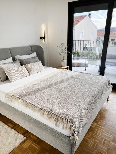 a large bed in a bedroom with a large window at Meldaria Residence in Krk