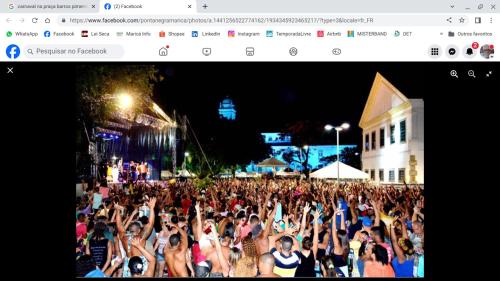 a large crowd of people dancing in front of a concert at 50 metros da praia - pé na areia in Maricá