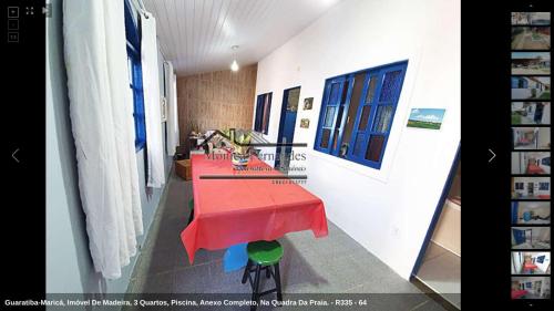 a long room with a red table in it at 50 metros da praia - pé na areia in Maricá
