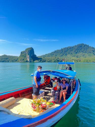 a group of people sitting on a boat in the water at Bnเกาะลิบงโฮมสเตย์ in Ko Muk