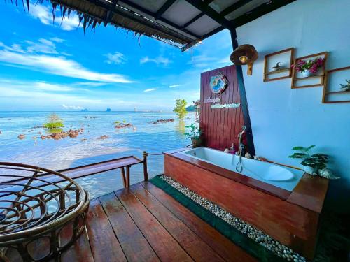 a bath tub sitting on a deck next to the water at Bnเกาะลิบงโฮมสเตย์ in Ko Muk
