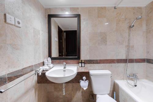 a bathroom with a toilet and a sink and a mirror at Private Apartment 6503 at the Jayakarta Residence in Seminyak